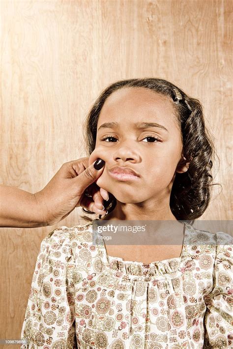 Young Girl Smiling And Being Pinched On The Cheek High Res Stock Photo