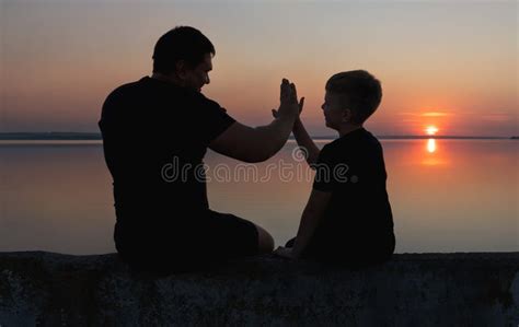 Strong Friendship Between Father And Sonfather And Son Sitting On The Promenade And Watch The