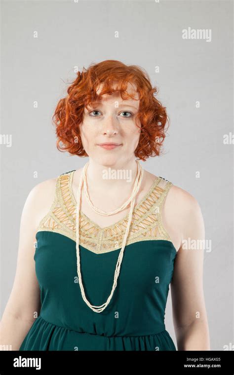 Pretty Redhead Woman In Green Dress And Pearl Looking At The Camera