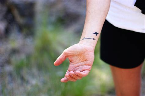 This monochrome little bird is sitting on a thin branch, the tattoo is located on the wrist and may be a lucky charm for the owner. Inked Bird Love Wrist Tattoo