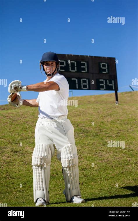 Cricket Player Swinging Bat While Standing At Field Stock Photo Alamy