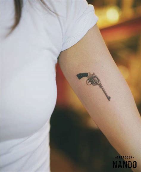 Small Fine Line Style Revolver Tattoo On The Left Inner