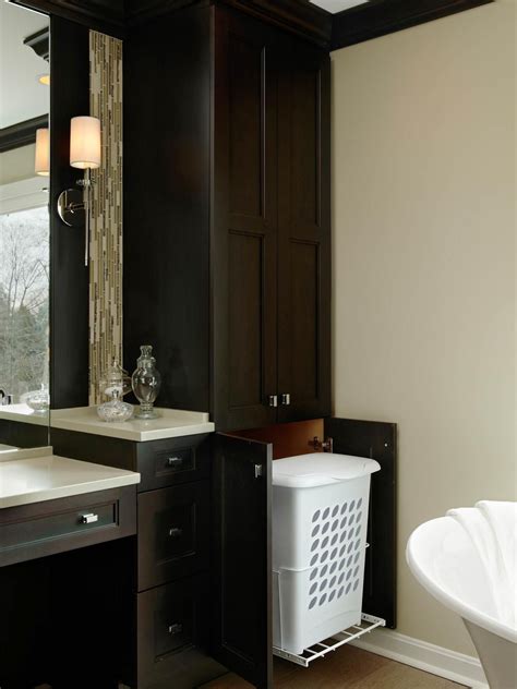 A transitional master bathroom features custom cabinetry with a hamper