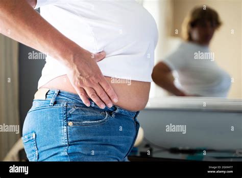 Older Overweight Woman With Excess Body Fat Looking In Mirror Stock