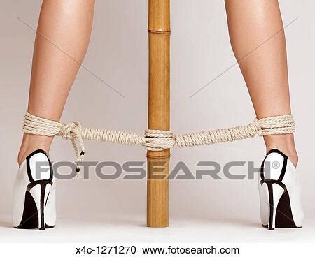 Sexy Woman Legs Tied With Bondage Ropes To A Bamboo Pole Stock Image