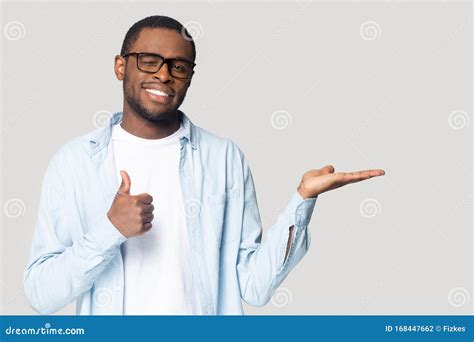 Attractive African Guy Showing Open Palm And Thumbs Up Gesture Stock
