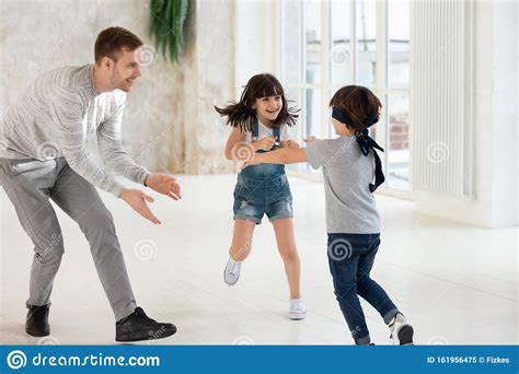 Overjoyed Young Father Playing With Laughing Daughter And Son Stock