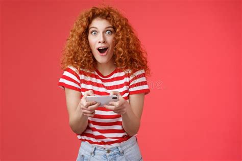 Impressed Excited Good Looking Redhead Curly Woman Hold Smartphone Horizontal Open Mouth