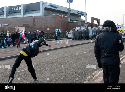 belfast uk 12 01 13 a loyalist youth throws a rock at riot police as rioting breaks in