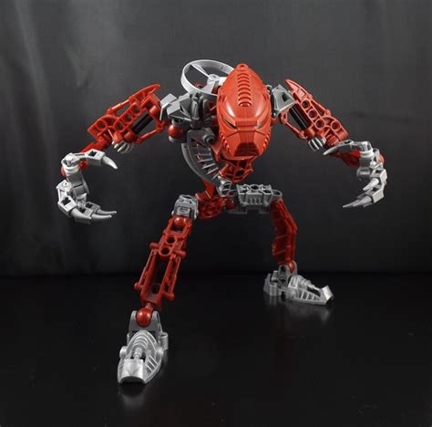 A Red And Silver Robot Standing On Top Of A Table