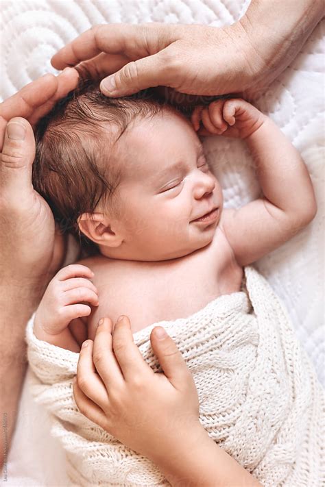 Portrait Of A Newborn Baby With Hands Of The Family Del Colaborador De Stocksy Lea Csontos