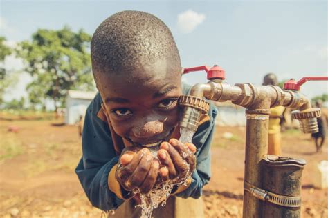 Young Boy Drinks Safe Water From A Tap In Nyarugusu Refugee Camp