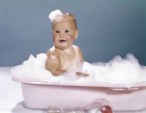 1960s Smiling Baby Sitting In Bathtub Bubble Bath Covered With Soap