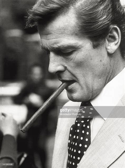 A Close Up Of The British Actor Roger Moore Smoking A Cigar Description From Gettyimages Com I