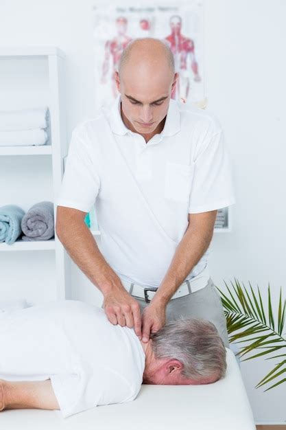 Premium Photo Physiotherapist Doing Neck Massage To His Patient