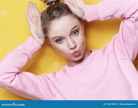 Portrait Of Playful Young Pretty Blond Woman Showing Horns And Making Faces Isolated On Yellow