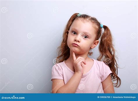 Fun Confused Kid Girl Thinking And Looking Serious About On Blue Stock