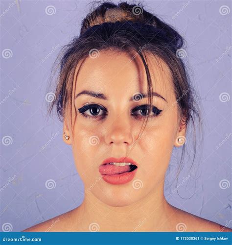 Portrait Of Beautiful Girl On A Blue Background Showing Tongue Stock