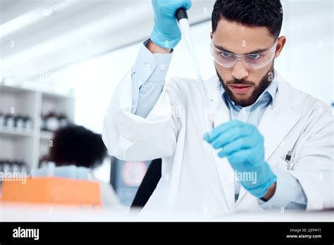 One Mixed Race Male Scientist Wearing Safety Goggles And A Labcoat