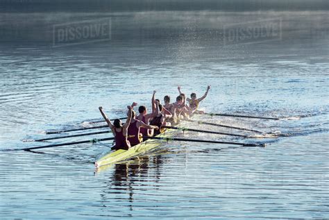 Rowing Team Celebrating In Scull On Lake Stock Photo Dissolve
