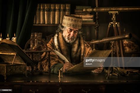 Astronomer Writing On Parchment With Feather Pen High Res Stock Photo