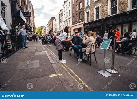 People Sitting On The Busy Restaurant Terrace In Soho Area During