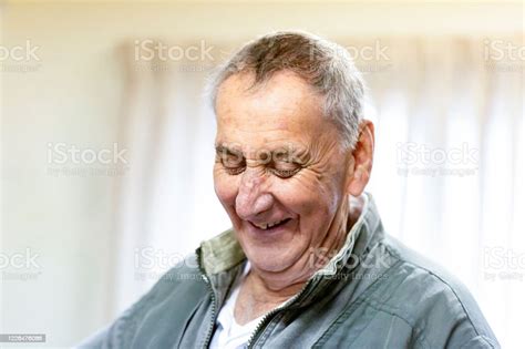 Portrait Of Laughing Senior Man Looking Down Background With Copy Space