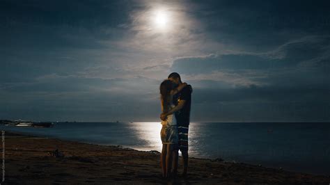 Romantic Couple Kissing Under The Full Moon By Stocksy Contributor