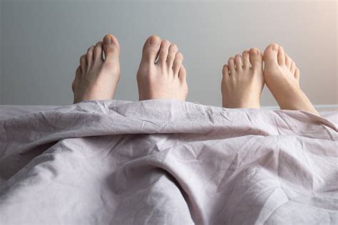 Man And Woman Legs On Bed Couples Feet In Bed Close Up Stock Photo