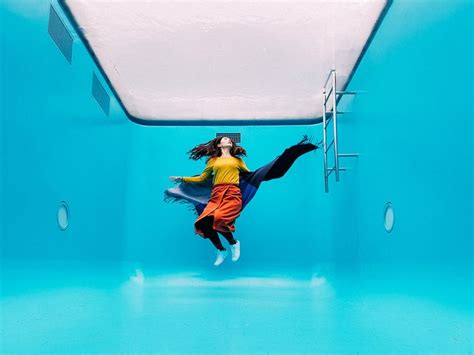 floating inside the permanent swimming pool exhibition of argentinian artist leandro erlich at