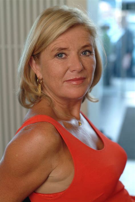 A Woman In An Orange Top Posing For A Photo
