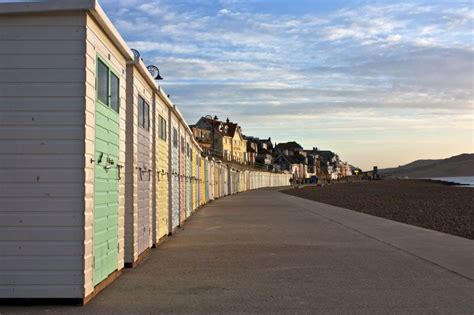 A Row Of Beach Huts Next To The Ocean