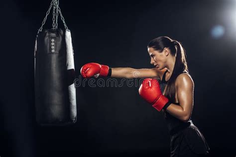 Side View Of Female Boxer In Red Boxing Gloves Training With Punching