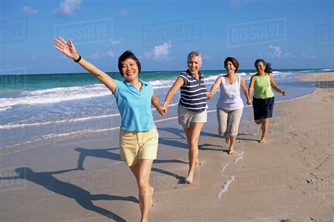 Senior Women Running On Beach Stock Photo Dissolve