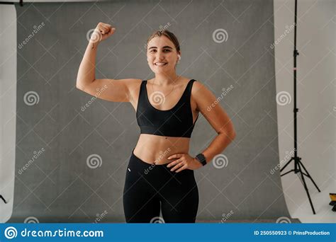 Young Woman Flexing Her Arm Muscles In A Studio Stock Image Image Of
