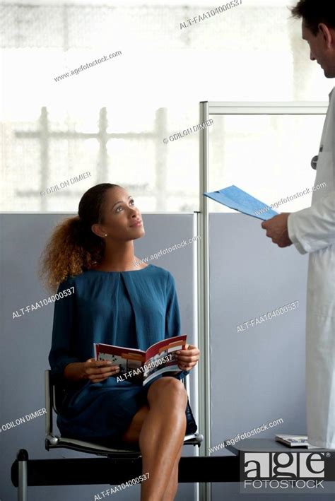 Doctor Chatting With Patient In Waiting Room Stock Photo Picture And