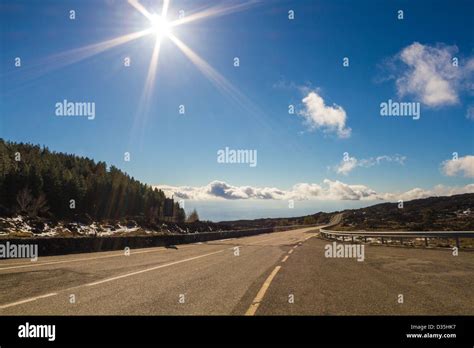 Long Lonely Road In Front Of Blue Sky And Mountains Stock Photo Alamy