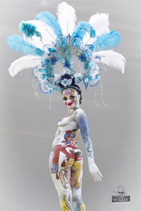 A Woman With Blue And White Feathers On Her Head Is Standing In The