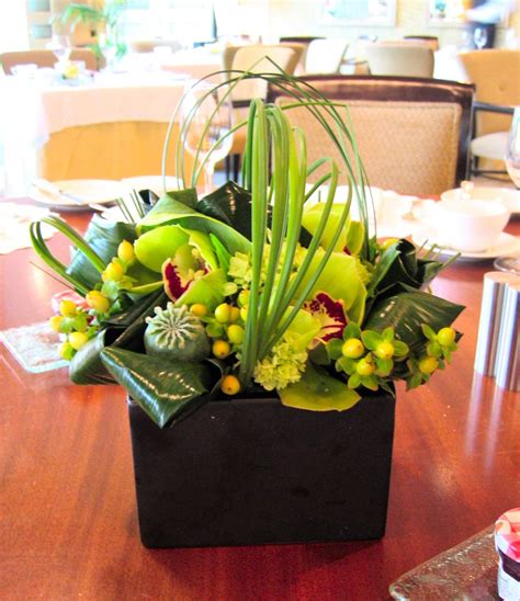 Modern Flower Arrangement With Green Cymbidium Orchids Hypericum Berries Poppy Pods And