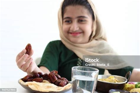 adorable smiling pakistani muslim girl with beautiful eyes with hijab hold date fruits enjoy