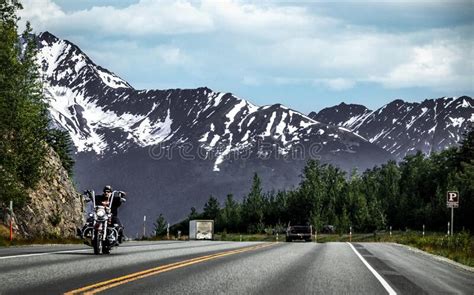 Alaska Usa Motorcycle On Road With Stark Mountains With Snow In