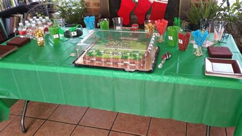 a green table topped with a cake covered in frosting