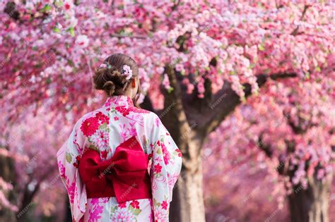 Premium Photo Woman In Yukata Kimono Dress Looking Sakura Flower Or