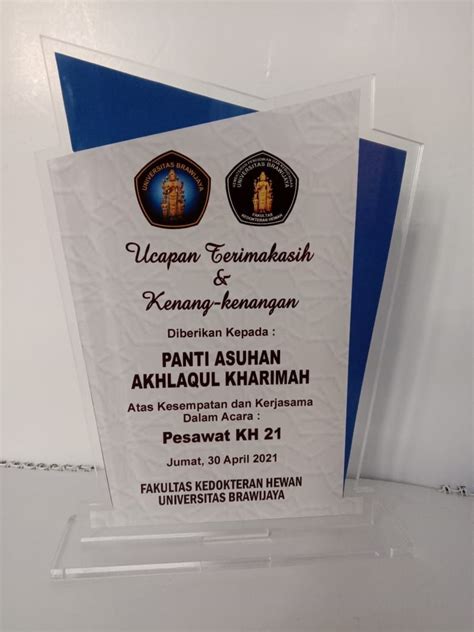 An Award Plaque Is Displayed On A White Surface With Blue Trimmings And