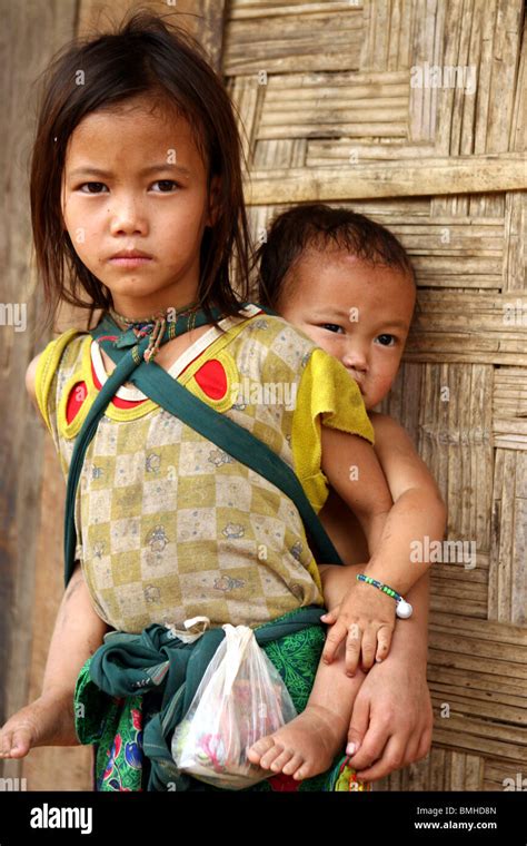 Enfants Hmong portant son frère dans un petit village entre Pakbeng et Luang Prabang Laos Photo
