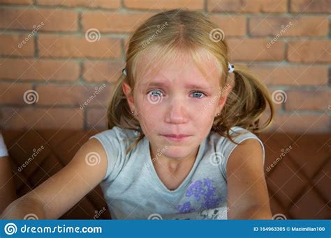 Little Blond Crying Girl With Sad Expression And Tears Stock Image