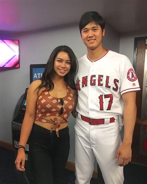 A Man And Woman In Baseball Uniforms Posing For A Photo