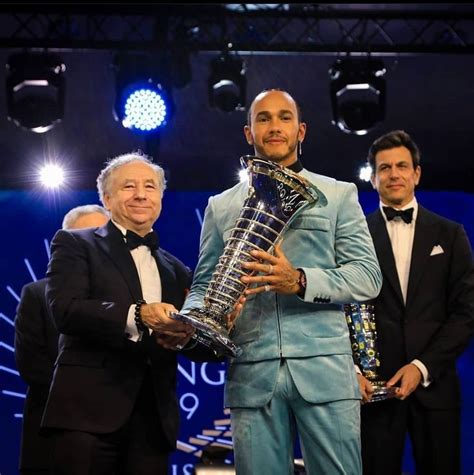 Three Men In Tuxedos Pose For A Photo While One Holds Up The Trophy
