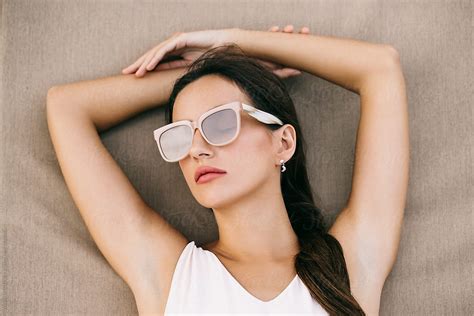 Overhead Closeup Of Beautiful Brunette With Pink Sunglasses Relaxing