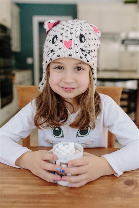 Cute Young Girl In A Winter Hat Drinking Hot Chocolate With